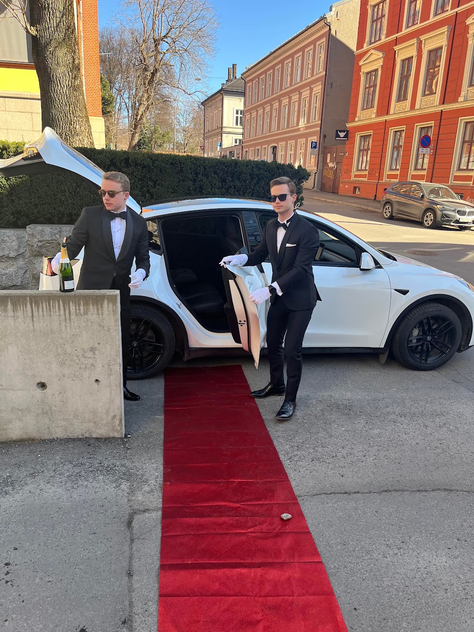 Red carpet limousine service with chauffeurs in tuxedos